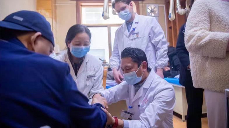 Tuden Basang (middle) is doing wrist hand consultation for patients under the guidance of tutor Zhang Wei.