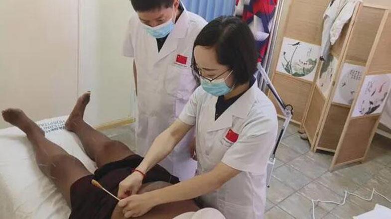 Hu Sha (first from right) and his colleagues are giving acupuncture therapy to patients.